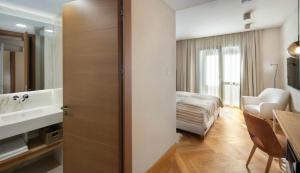 Cette chambre d'hôtel dispose d'une salle de bains avec un lit et un lavabo. dans l'établissement Skigyimes Hotel, à Lunca de Sus