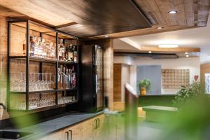 een bar met een plank met alcoholflessen bij Gaia Residence Hotel in Mezzana