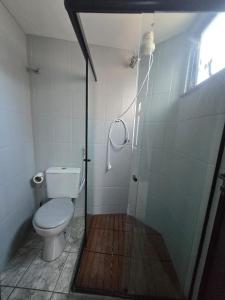 een badkamer met een toilet en een douche met een glazen deur bij Loft Recanto Dos Cavalheiros! Com Ar Condicionado! in Macaé +11 foto's