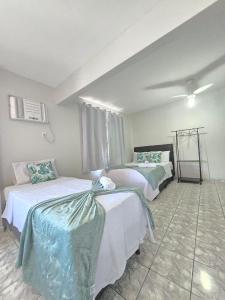 een slaapkamer met twee bedden in een kamer bij Loft Recanto Dos Cavalheiros! Com Ar Condicionado! in Macaé