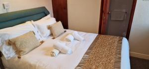 een bed met witte lakens en kussens erop bij Lily Hotel Blackpool in Blackpool