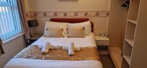 een slaapkamer met een bed met witte lakens en kussens bij Lily Hotel Blackpool in Blackpool