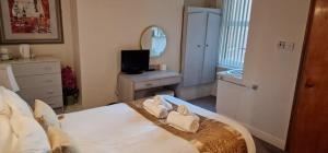 een slaapkamer met een bed, een ladekast en een spiegel bij Lily Hotel Blackpool in Blackpool +2 foto's