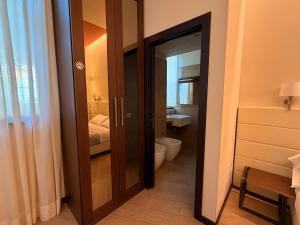 bagno con porta aperta su un bagno con servizi igienici di Arena Luxury Suite a Verona
