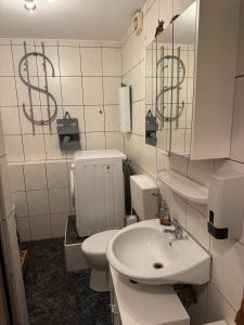 een badkamer met een wit toilet en een wastafel bij Wohnung wie Zuhause in Bergheim