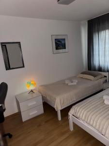 een slaapkamer met twee bedden en een bureau met een lamp bij Wohnung wie Zuhause in Bergheim +20 foto's