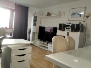 een woonkamer met een flatscreen-tv en een tafel bij Wohnung wie Zuhause in Bergheim