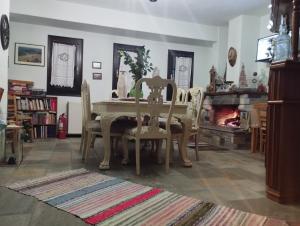 een eetkamer met een tafel en stoelen en een open haard bij Dimosthenis Karastamatis Rooms in Xorychti