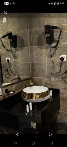 ein Badezimmer mit Waschbecken und zwei Telefonen an der Wand in der Unterkunft شقق مسكن الضيافة للشقق المخدومة in Dammam