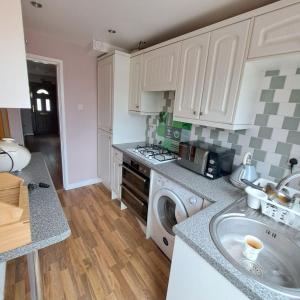 a kitchen with a sink and a washing machine at Little puppy in Birmingham