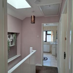 a hallway with pink walls and a ceiling at Little puppy in Birmingham