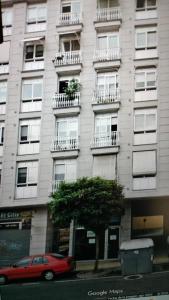 ein rotes Auto, das vor einem Gebäude geparkt ist in der Unterkunft Mirador Residencia in Ourense