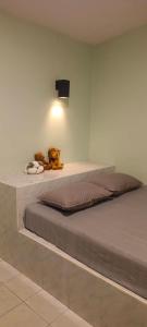 un letto con un animale di peluche seduto sopra di esso di D Love Gueshouse a Ranong