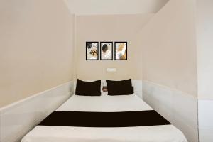 Bett in einem Zimmer mit drei Bildern an der Wand in der Unterkunft Hotel O Arambol Beach Formerly Hakuna Matata in Arambol + 22 Fotos