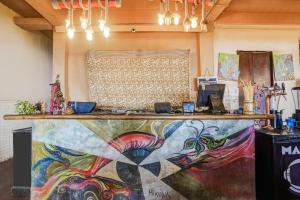 eine Theke in einem Raum mit einem Gemälde an der Wand in der Unterkunft Hotel O Arambol Beach Formerly Hakuna Matata in Arambol