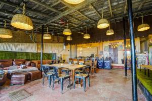 ein Restaurant mit Tischen und Stühlen in einem Raum in der Unterkunft Hotel O Arambol Beach Formerly Hakuna Matata in Arambol