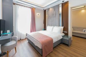 een hotelkamer met een bed, een bureau en een televisie bij VE Hotels Adakale in Yenişehir
