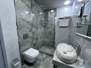 a bathroom with a shower and a toilet and a sink at Amber Hotel in Baku