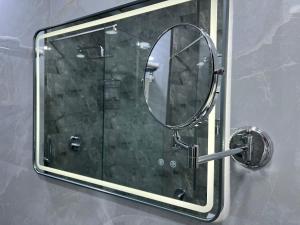 a mirror on a glass wall in a bathroom at Amber Hotel in Baku