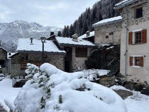 een groep met sneeuw bedekte gebouwen in een besneeuwde tuin bij Riverside Room Joseph in Pontboset +20 foto's
