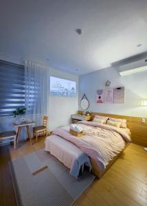 a bedroom with a large bed and a table at BaBô Homestay Da Nang in Danang