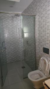 a bathroom with a toilet and a glass shower at Venus Apartment in Nairobi