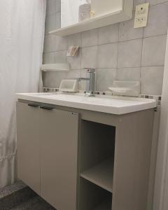 een badkamer met een witte wastafel en een spiegel bij Patri Hotel in Chivilcoy