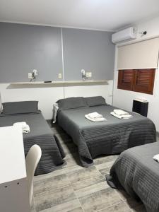 een hotelkamer met twee bedden en een spiegel bij Patri Hotel in Chivilcoy