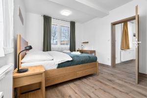 een slaapkamer met een bed, een bureau en een raam bij George 01 by Mountain ways in Kovářská