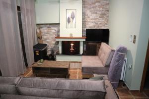 a living room with a couch and a fireplace at Villa Elea in Milies Pelion in Mileai
