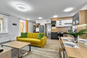 een woonkamer met een gele bank en een tafel bij George 01 by Mountain ways in Kovářská