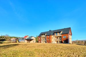 een groot gebouw met een veld ervoor bij George 01 by Mountain ways in Kovářská