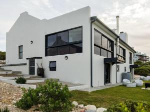 une maison blanche avec des fenêtres noires dans l'établissement Protea32, à Agulhas