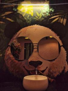ein Badezimmer mit einem Gemälde eines Affen mit Brille in der Unterkunft Annandam Inn(Hotel Anand) in Seonī
