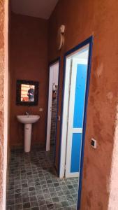 a bathroom with a sink and a window and a door at Atlas lodge in Sidi Hassaïn
