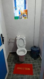 a small bathroom with a toilet with a red rug at Atlas lodge in Sidi Hassaïn