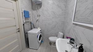a white bathroom with a toilet and a sink at Уютная квартира в Одессе in Odesa +15 photos