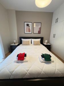 een slaapkamer met een groot wit bed met handdoeken erop bij G&M Home in Elassona