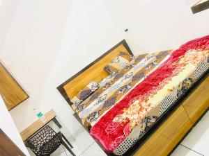 a bed with a red and gold blanket on it at Dh Hotel in Bhiwāni