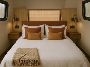 a bedroom with a large white bed with pillows at Caravan Hatta by Our Habitas in Hatta