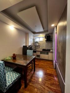 un salon avec une table et une cuisine dans l'établissement Triluna Apartments, à Pātan