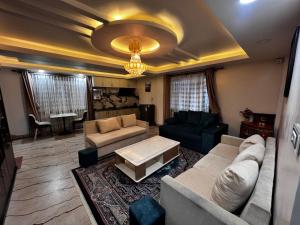 un salon avec un canapé et une table dans l'établissement Triluna Apartments, à Pātan