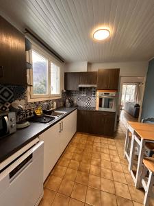 a kitchen with wooden cabinets and a table in it at Chez Négus in Laruns