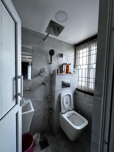 une salle de bains avec toilettes et lavabo dans l'établissement Triluna Apartments, à Pātan