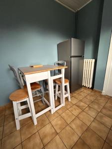 a kitchen with a table and chairs and a refrigerator at Chez Négus in Laruns +4 photos