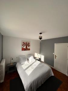 a bedroom with a large white bed in it at Chez Négus in Laruns