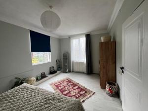 een slaapkamer met een bed en een tapijt op de vloer bij Almadovarhouse in Makhinjauri