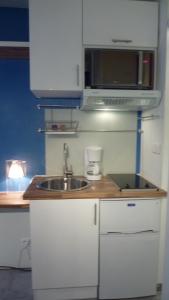 a kitchen with a sink and a microwave at Studio meublé Centre ville in Bastia