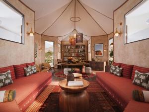 a living room with red couches and a table at Caravan Hatta by Our Habitas in Hatta