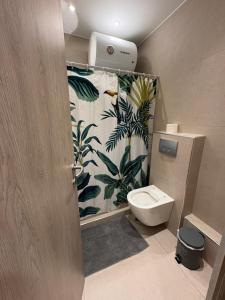 een badkamer met een toilet en een tropisch douchegordijn bij G&M Home in Elassona +24 foto's